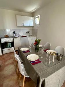 a kitchen with a table with white plates on it at Reževići apartment Lav in Reževići +10 photos