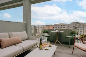 a living room with a couch and a table on a balcony at Wilde Aparthotels Lisbon Liberdade in Lisbon