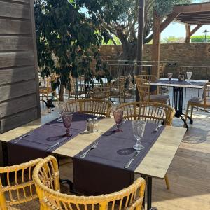 a table with wine glasses and chairs on a patio at Hôtel La Lagune in Lucciana