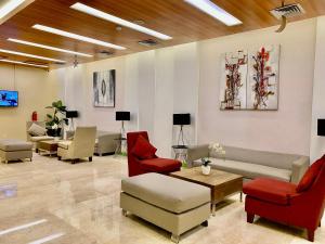 a waiting room with chairs and a couch and a table at Whiz Prime Hotel Kelapa Gading in Jakarta