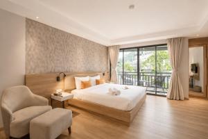 a bedroom with a bed and a chair and a window at Zostel Phuket, Patong Beach Hostel in Patong Beach