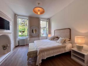 a bedroom with a large bed and two windows at Les Chambres Salonaises in Salon-de-Provence