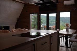 a kitchen and dining room with a table and windows at Colina Monteoru in Sărata-Monteoru