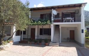 a villa with a balcony and a patio at Apartmani Sekana in Starigrad