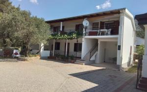 a large white house with a balcony and stairs at Apartmani Sekana in Starigrad