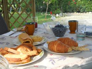 una mesa cubierta con platos de pan y bollería en I 99 ulivi, en Cavour