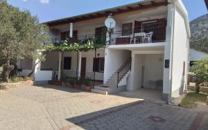a white house with a staircase and a balcony at Apartmani Sekana in Starigrad +44 photos