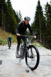 a woman riding a bike in the water at ArlbergResort Klösterle in Klösterle +63 photos