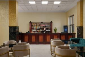 a room with a bar with chairs and tables and a counter at Ani Grand Hotel Yerevan in Yerevan