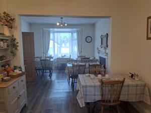 a kitchen and dining room with tables and chairs at Harbourlight Guesthouse in Saundersfoot