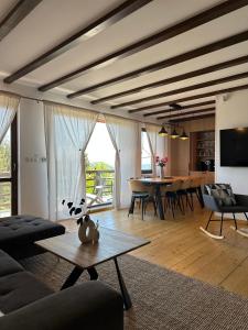 a living room with a couch and a table at Family Nest Băișoara - Confort Premium, Wi-Fi rapid, ciubăr la cerere și view spectaculos in Muntele Băişorii