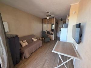 a living room with a couch and a table at Le Cocon de Laeti & Steph in Port Leucate