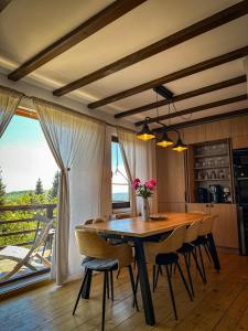 a dining room with a wooden table and chairs at Family Nest Băișoara - Confort Premium, Wi-Fi rapid, ciubăr la cerere și view spectaculos in Muntele Băişorii