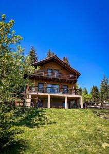 a large log house on top of a hill at Family Nest Băișoara - Confort Premium, Wi-Fi rapid, ciubăr la cerere și view spectaculos in Muntele Băişorii