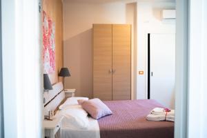 a bedroom with a bed and a dresser at Casamare Hotel in San Vincenzo