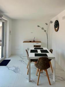 a dining room with a white table and chairs at Villa Olimpia in Civitavecchia