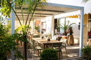 an outdoor patio with tables and chairs and plants at Casamare Hotel in San Vincenzo