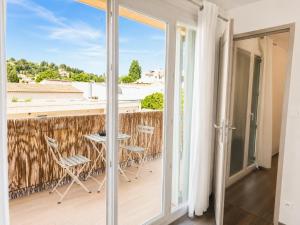 a room with a balcony with a table and chairs at Le Relais de la Calèche in Le Beausset