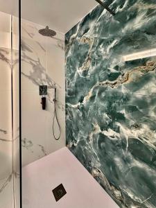 a bathroom with a shower with a green marble wall at Villa Olimpia in Civitavecchia +40 photos