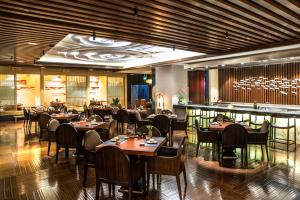 a restaurant with tables and chairs and a bar at Pullman Shanghai Xuhui in Shanghai