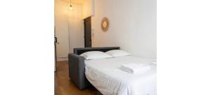 a bedroom with a bed with white sheets and pillows at Doux Pavillon - La Palmeraie in Nice