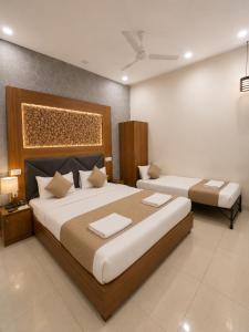 ein Hotelzimmer mit zwei Betten im Schlafzimmer in der Unterkunft Hotel Woodlark Square Zirakpur Chandigarh # Family Hotel # Property of the Year in Chandīgarh