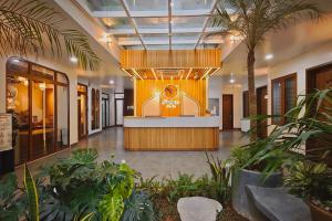 an office lobby with a reception desk and palm trees at Pataco Tam Coc Hotel in Vũ Lâm