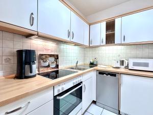 a kitchen with white cabinets and a sink at Rubiblick, Montana Haus in Oberstdorf