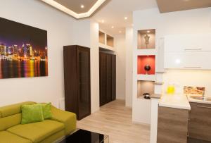 ブダペストにあるGreat Market Hall Apartmentのリビングルーム(緑のソファ付)、キッチンが備わります。