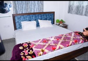 a bedroom with a large bed with a purple blanket at Hotel ram priya in Chhatarpur