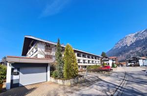a building with a garage in front of a mountain at Rubiblick, Montana Haus in Oberstdorf