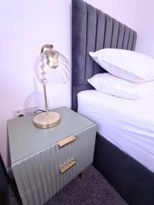 a lamp on a night stand next to a bed at Anex Highfield Guest House in Idle +11 photos