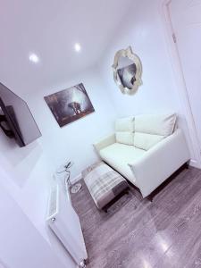 a white room with a couch and a mirror at Anex Highfield Guest House in Idle
