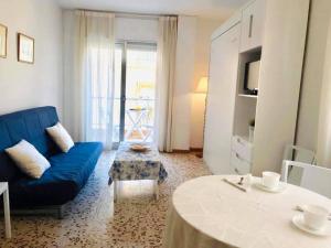 a living room with a blue couch and a table at Apartamentos Pagán Alejandro in San Javier