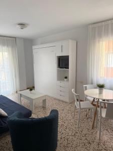 a living room with a couch and a table with chairs at Apartamentos Pagán Alejandro in San Javier