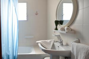 a bathroom with a sink and a mirror and a tub at Apartamentos Pagán Alejandro in San Javier +15 photos