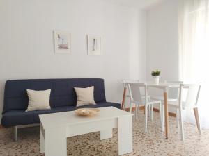a living room with a blue couch and a table at Apartamentos Pagán Alejandro in San Javier