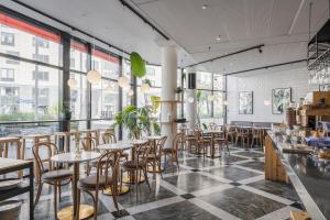 a restaurant with tables and chairs and windows at 2Home Hotel Apartments in Solna