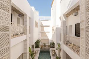 an internal courtyard of a house with white walls and balconies at Riad Origines in Marrakesh