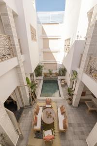 an indoor courtyard with a pool in a building at Riad Origines in Marrakesh