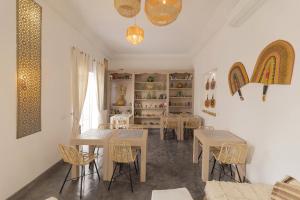 a dining room with tables and chairs and a shelf at Riad Origines in Marrakesh