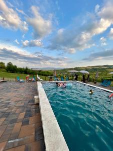 a swimming pool with people in the water at Mosia Dar In Rai in Berbeşti