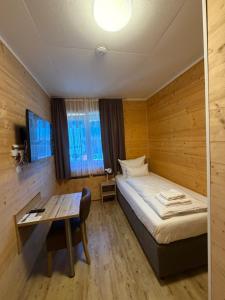 a small room with a bed and a table at URBAN OAK Smart Stay in Cologne