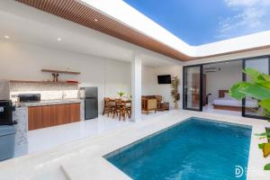 an indoor swimming pool in a house with a kitchen at Villa didi By sedana cottage in Pererenan