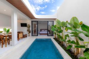 an indoor swimming pool with a skylight in a house at Villa didi By sedana cottage in Pererenan