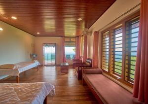 a bedroom with a bed and a room with windows at Celestial Heights Coorg by VOYE HOMES with Sunset views-Near to Nagarhole Tiger Reserve in Srimangala