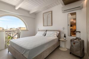 a white bedroom with a large bed and a window at Suite 33 - Boutique Apartments in San Benedetto del Tronto
