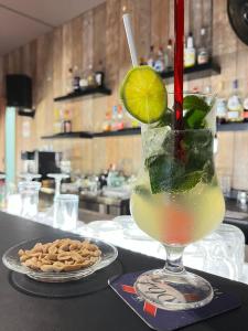 a drink in a glass with a lime on a counter at Azuri Lodge Piscine Privée Marina Golf in Saint-François