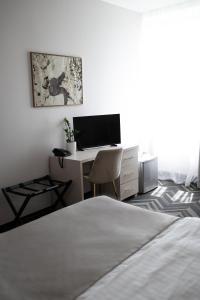 a bedroom with a bed and a desk with a computer at Aviator Hotel in Radom