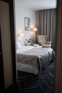 a hotel room with a large bed and a chair at Aviator Hotel in Radom